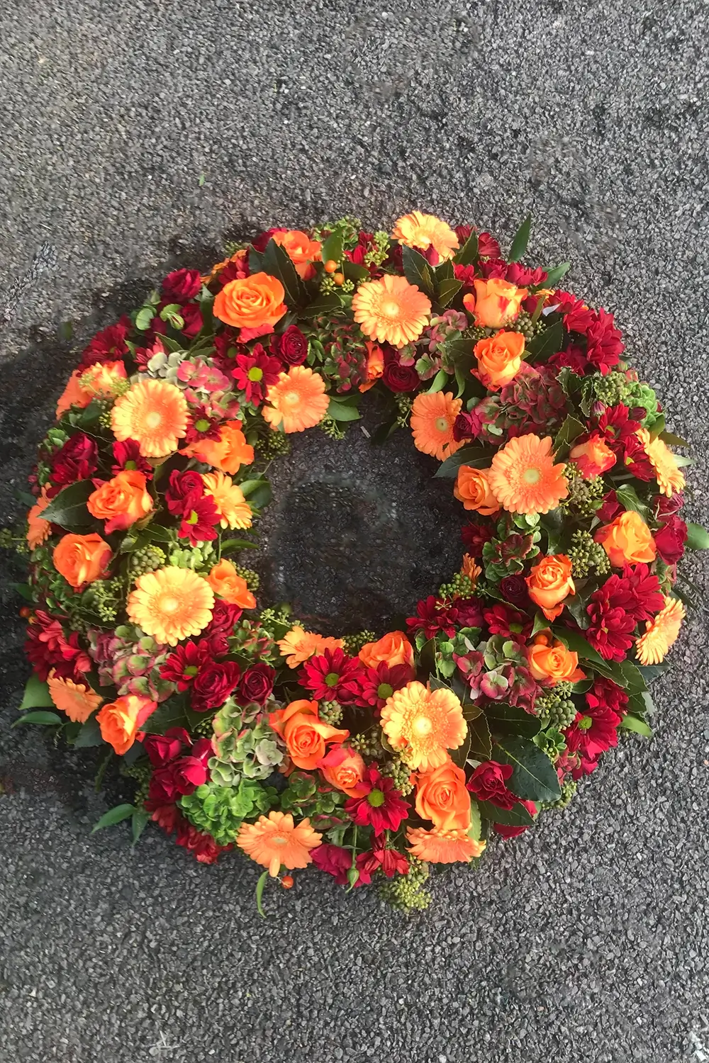 Funeral flowers orange and red wreath