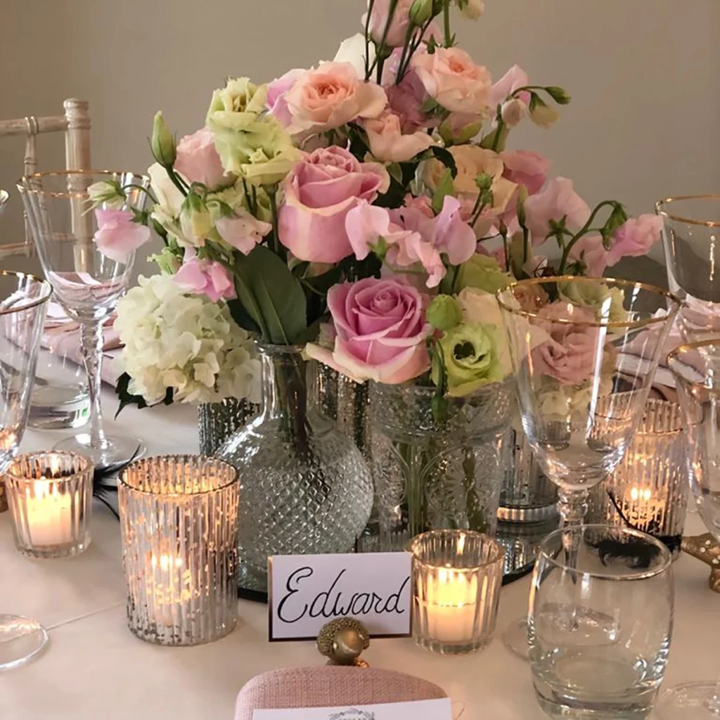 Pink and cream roses in glassware