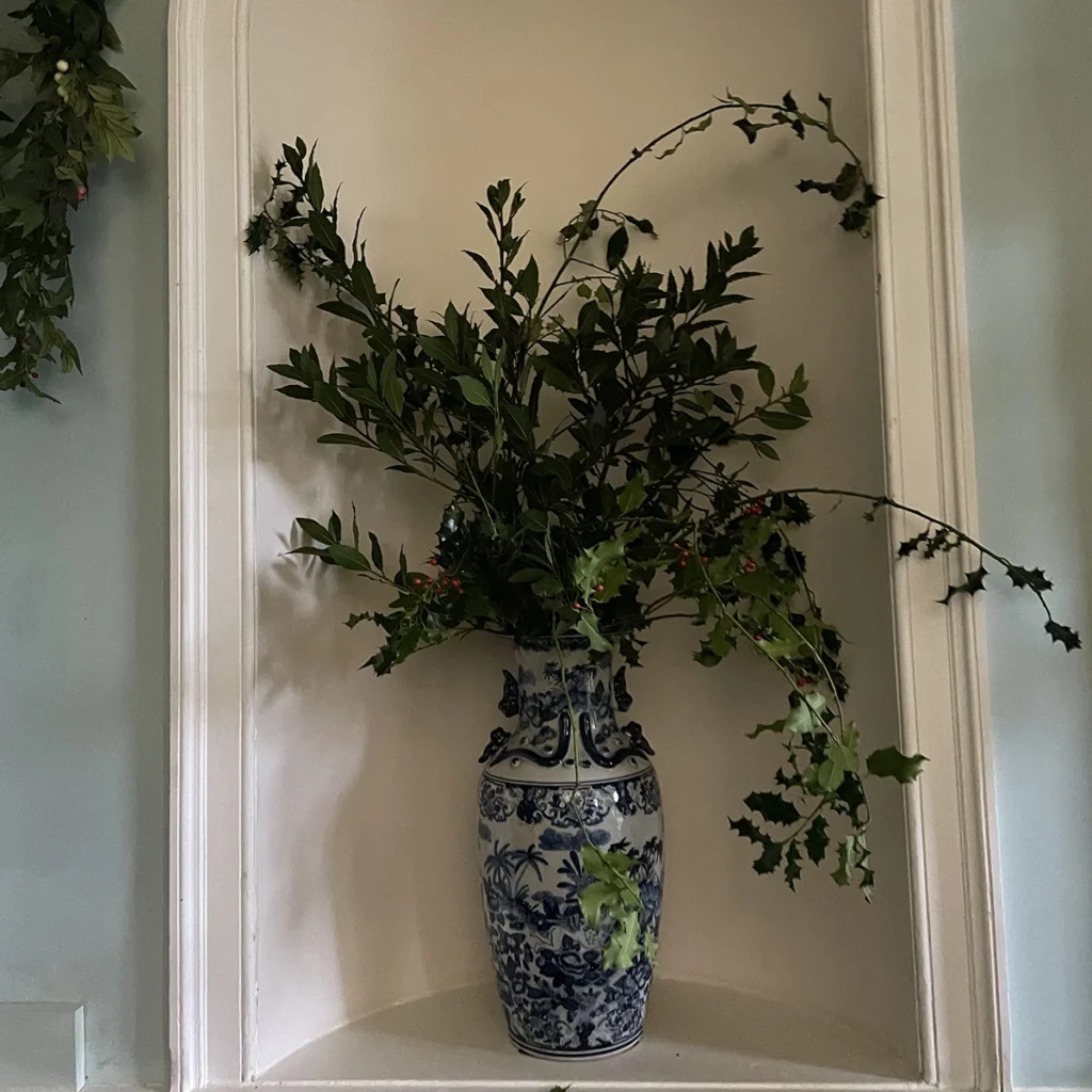 TV Oriental vase of holly in alcove